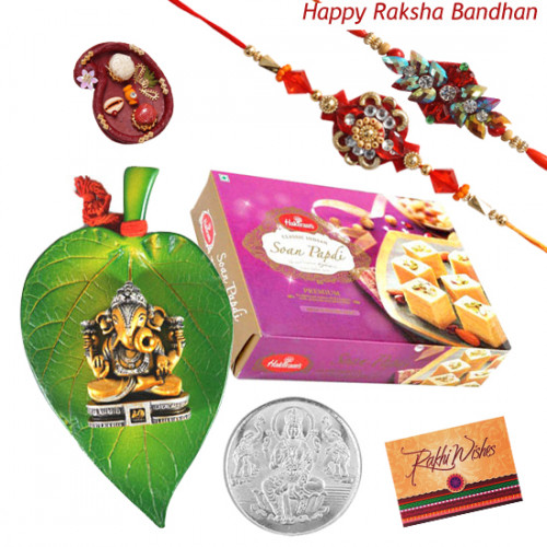 Rakhi Blessings - Laxmi Silver Coin 10 gms, Ganesh Ji On Leaf, Soan Papdi with 2 Rakhi and Roli-Chawal