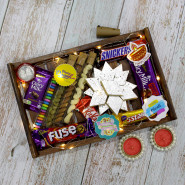 Sweet N Crunchy Tray - Kaju Katli, Almond in Glass Tube, Cashew in Glass Tube, Rasin in Glass Tube, Gems in Glass Tube, Snickers, Dairy Milk, Fruit n Nut, Fuse, Five Star, Kit Kat, 4 Diwali Props, Led Light, Wooden Tray with 2 Diyas and Laxmi-Ganesha Coin