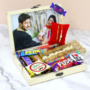Cheerful Charm - Almond in Glass Tube, Cashew in Glass Tube, Rasin in Glass Tube, Gems in Glass Tube, Fivestar, Snickers, Dairy Milk Fuse, Perk, 3 Rakhi Props, Personalized Wooden Box with 2 Rakhi and Roli-Chawal